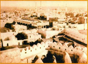 On the left side of the image, the old minaret and dome of the mosque are visible.