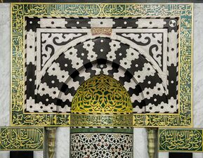 Decorations of the the Prophet's Mihrab with marble and gilding and verses from the Quran are written on it.