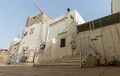 The exterior view of the mosque along with the surrounding houses and the public passage